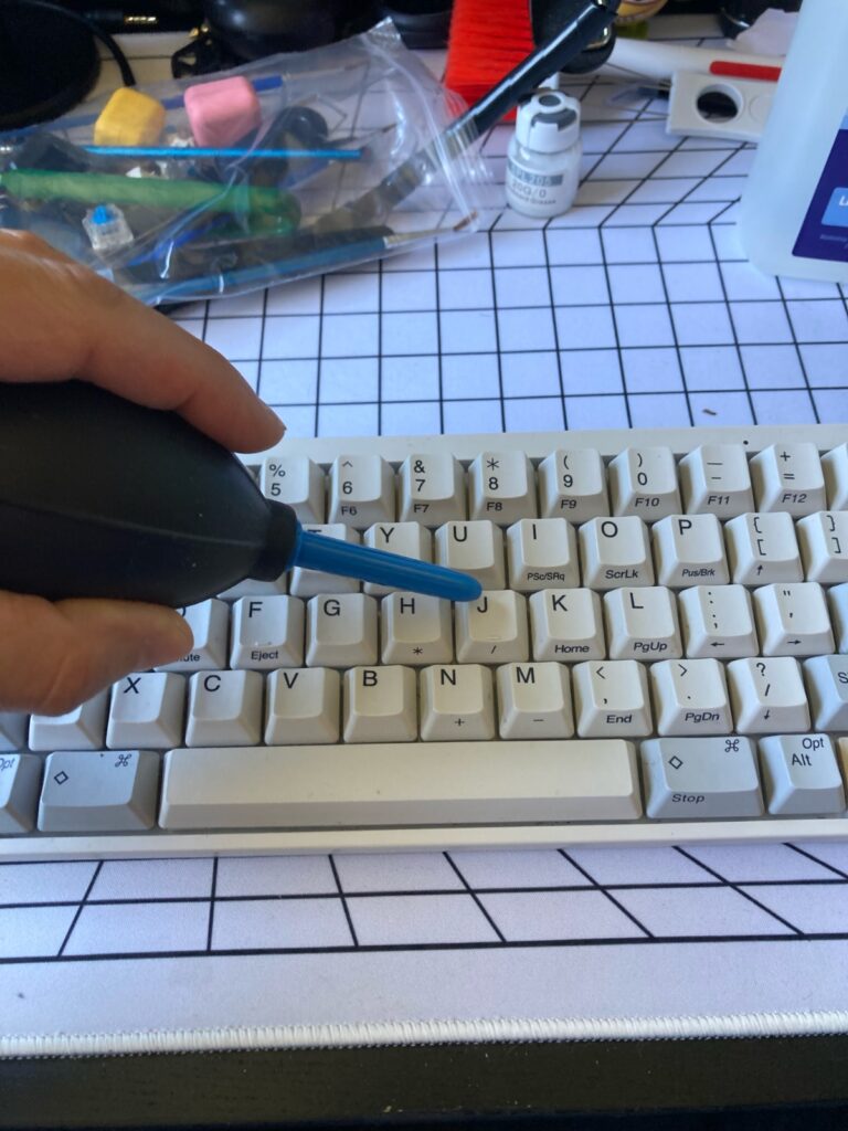 Limpiar teclado mecánico: podemos usar una perilla de fotografía para soplar aire entre las teclas.