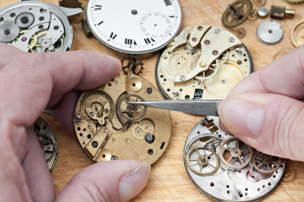 Interior de un reloj mecánico siendo arreglado por un relojero. 