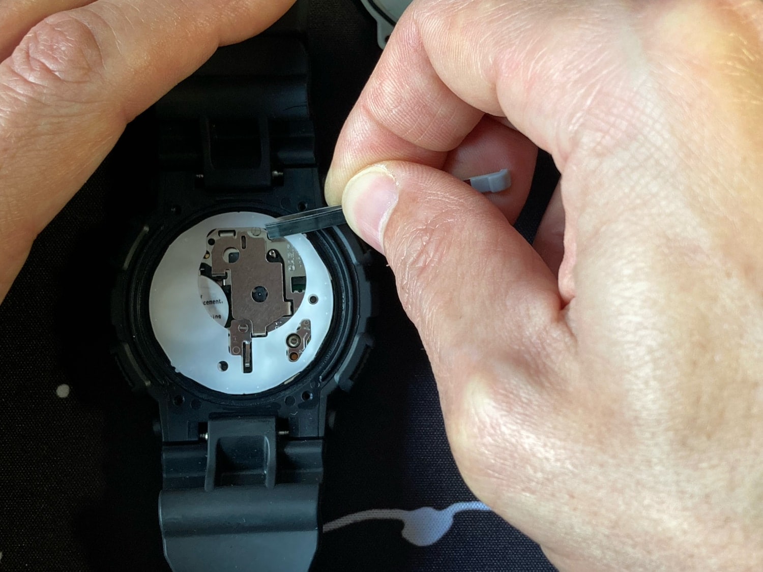 Guía para cambiar la pila del Casio G-Shock GA-100: quitamos la protección blanca de su interior con unas pinzas