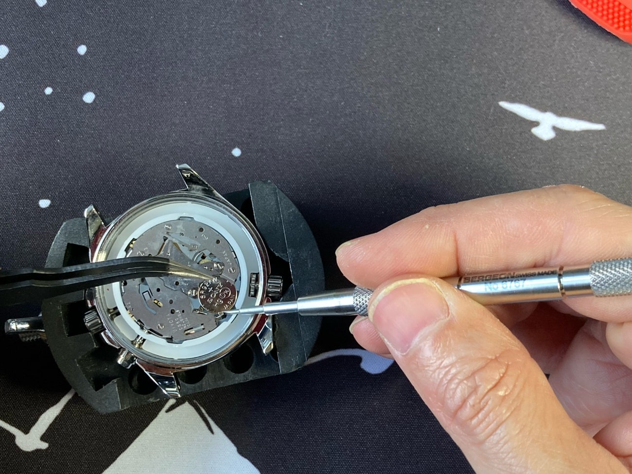 Cómo cambiar la pila del reloj Casio Edifice EF-527D: ponemos la pila con unas pinzas y tiramos de la sujeción metálica con otra herramienta. 