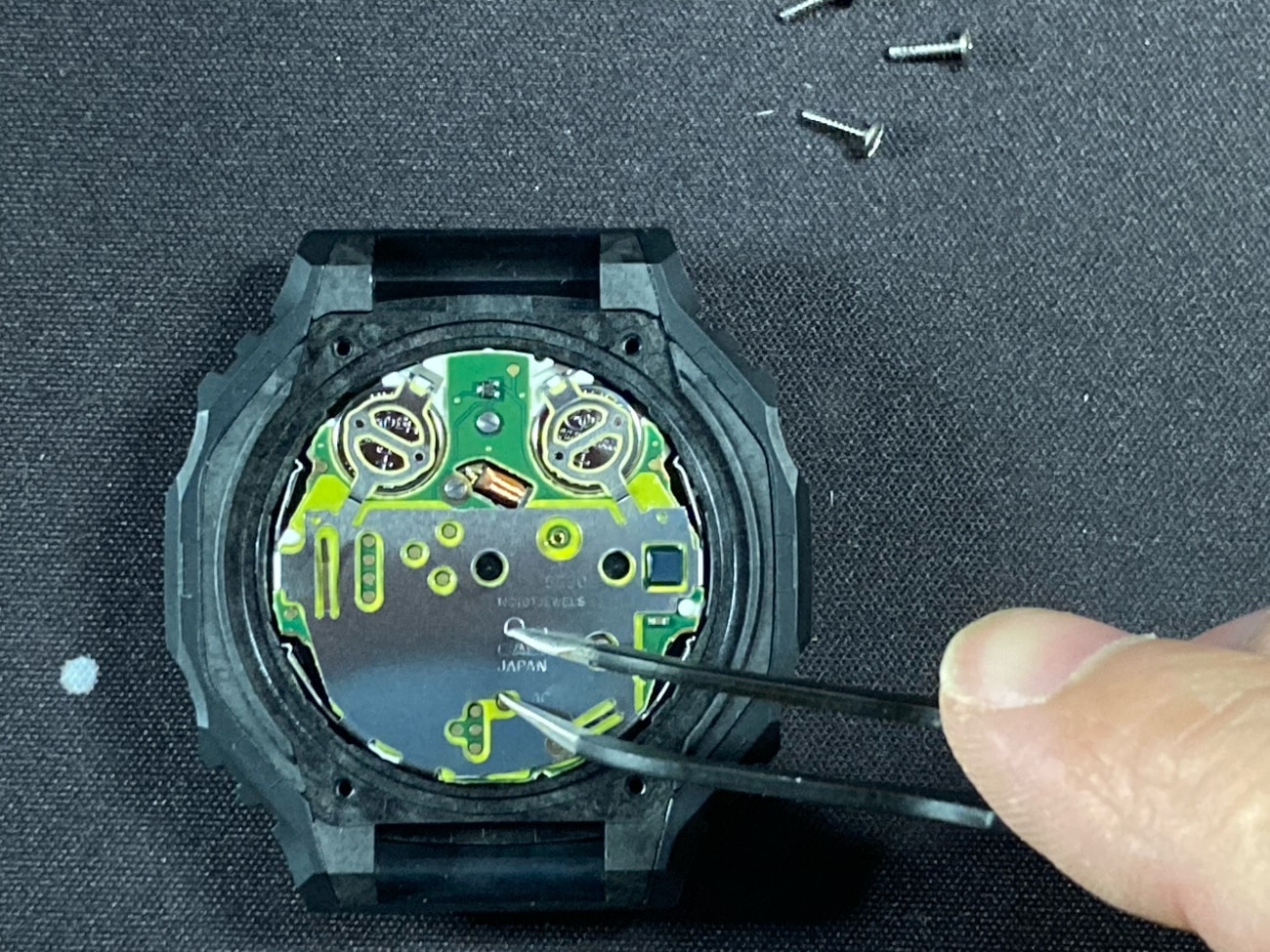 Cambio de pila en el Casio G-Shock GA-2100: Después del reemplazo de la batería, ponga en contacto AC con (-) usando unas pinzas