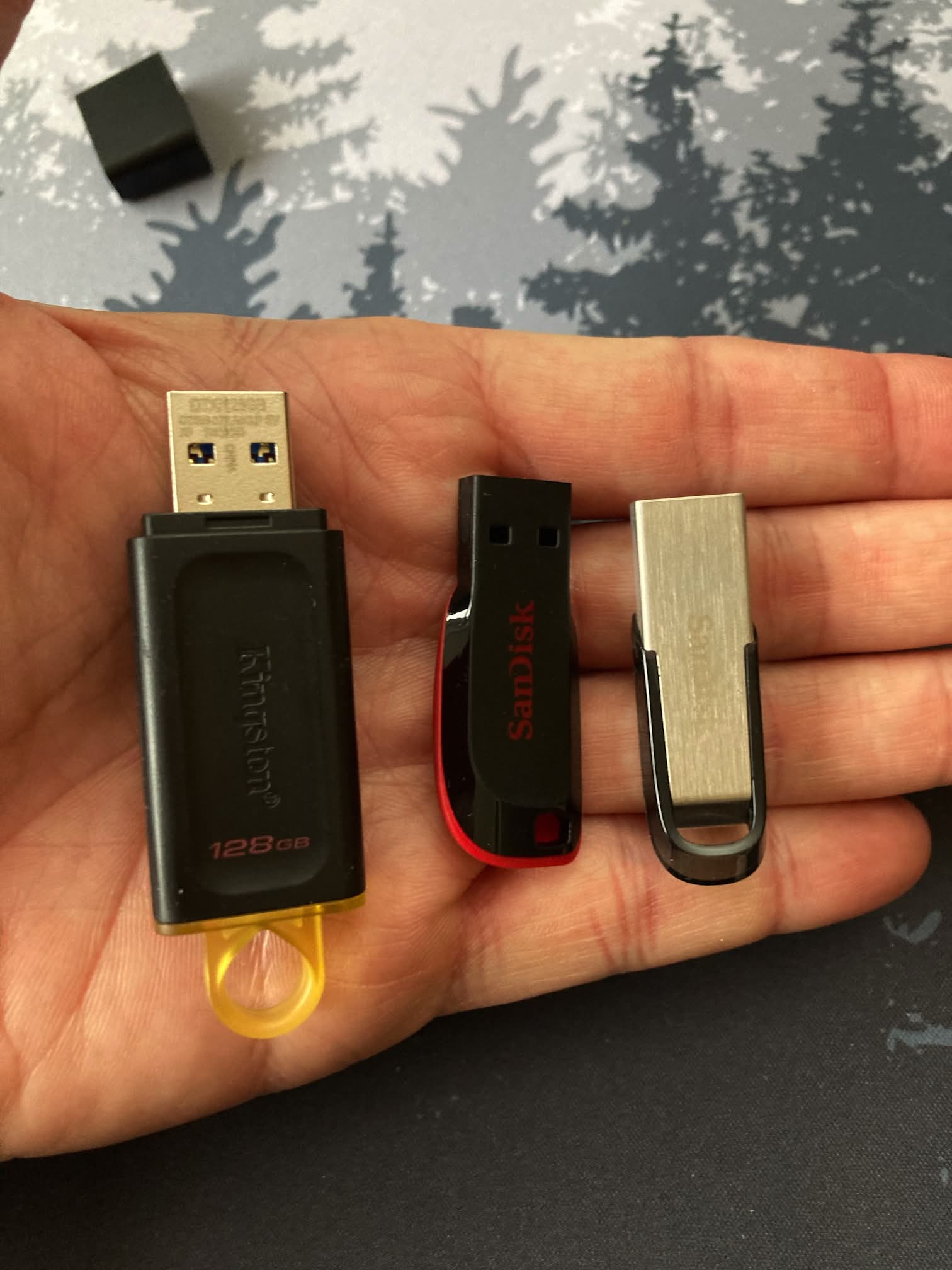 Kingston DataTraveler Exodia DTX/128GB USB 3.2 Gen 1, Cruzer Blade USB 2.0 de 64 GB y Sandisk Ultra Flair Memoria flash USB 3.0 de 64 en nuestra mano, para comprara el tamaño.