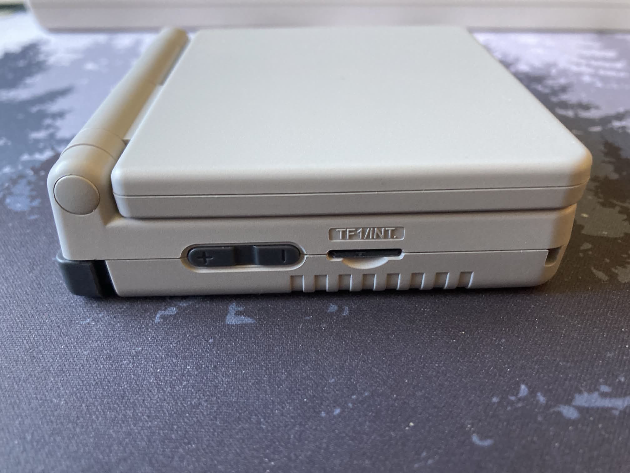 ANBERNIC RG 34XXSP: lateral iquierdo con botones de volumen y ranura tarjeta microSD