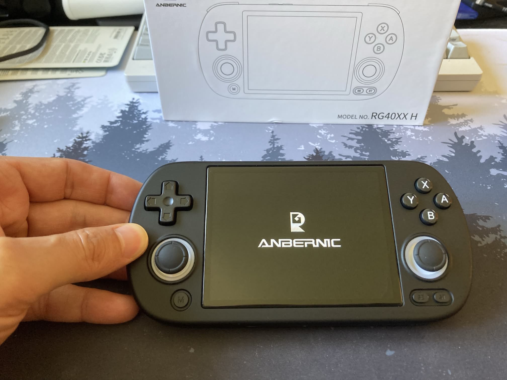 Anbernic RG40XX H: en nuestra mano. Es una consola con pantalla horizontal y mandos y botones a ambos lados.