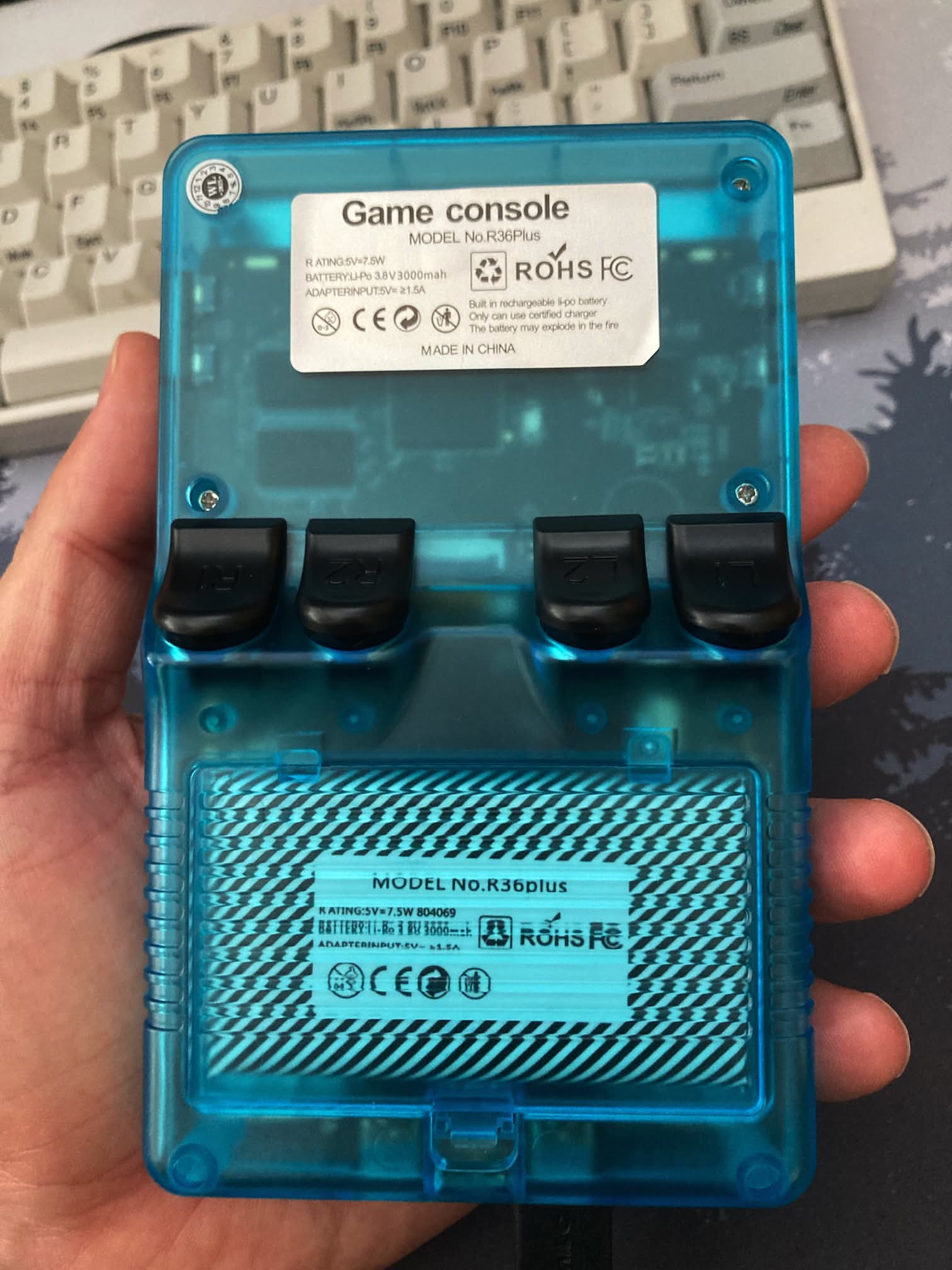 R36Plus consola en color azul: Parte trasera con tapa de batería y controles L y R.
